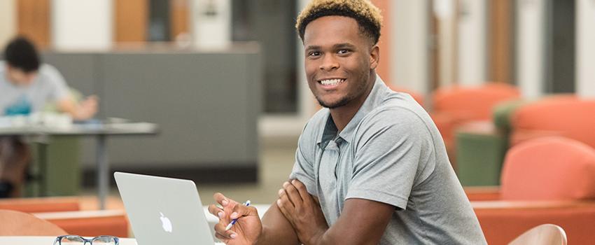 Male student working on laptop.